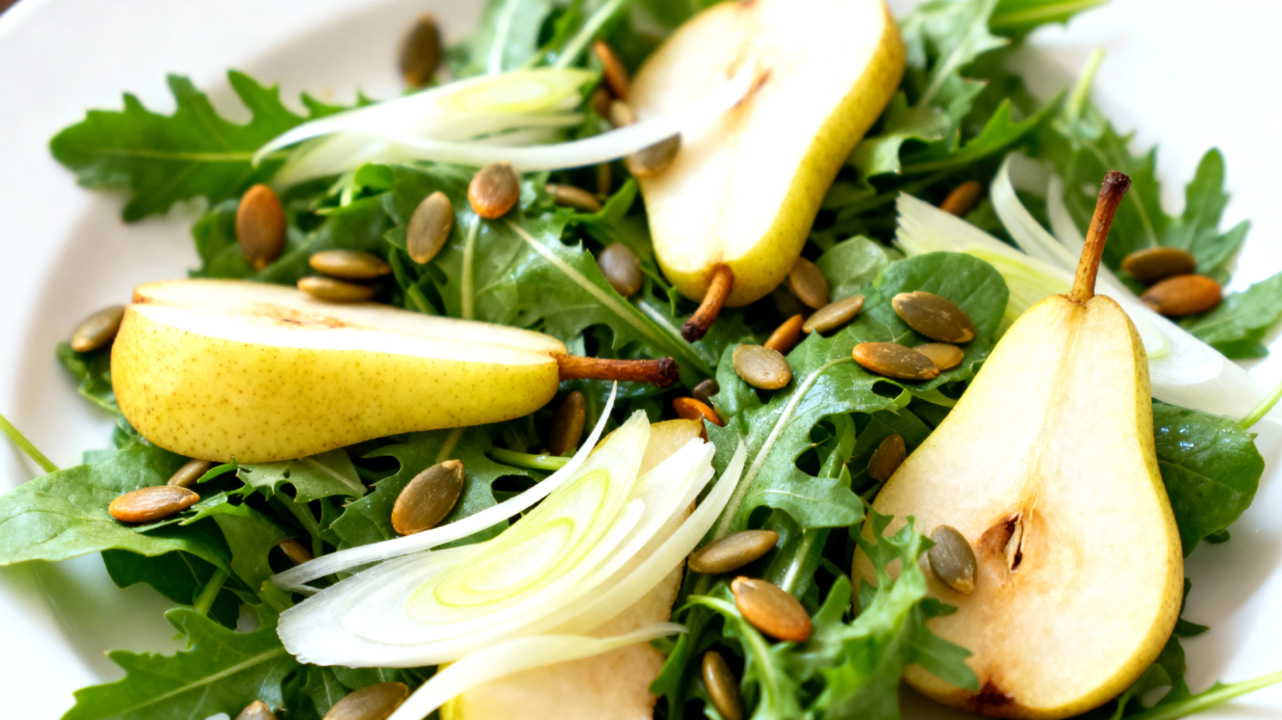 Löwenzahn-Birnen-Salat mit gerösteten Kürbiskernen und Fenchel"